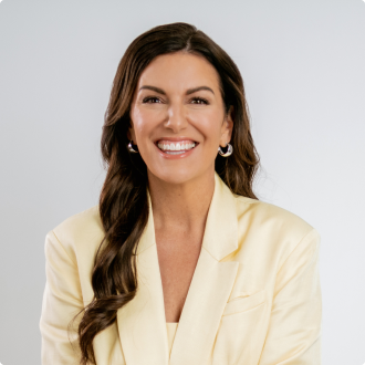 Amy Porterfield smiling in a blazer.