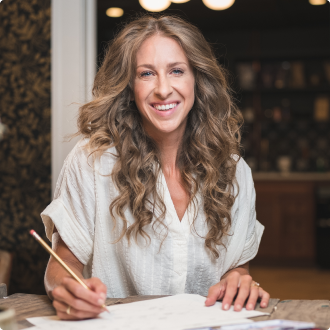 Bonnie Christine smiling while working on paperwork.