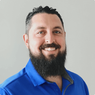 Jason Boehning smiling and posing in a blue shirt.