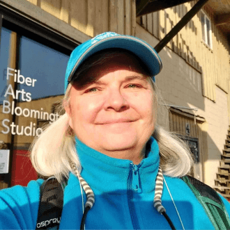 Jean Haley smiling while outside wearing a blue hat.