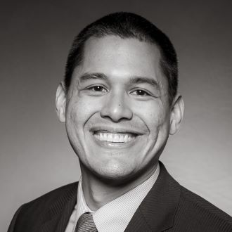 Juan R. Arroyo Yap wearing a suit while smiling at the camera.